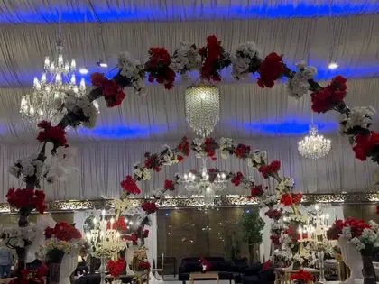 A red rose aisle under floral arches